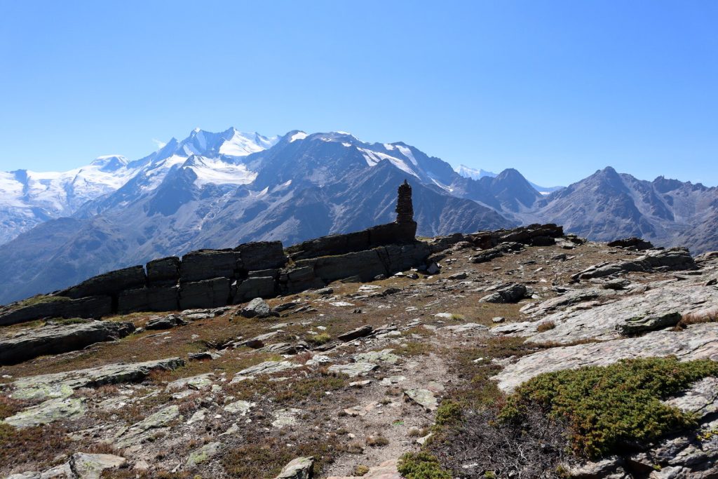 Kamienny obelisk Sattel na tle najwyższych w okolicy: Domu i Täschhornu
